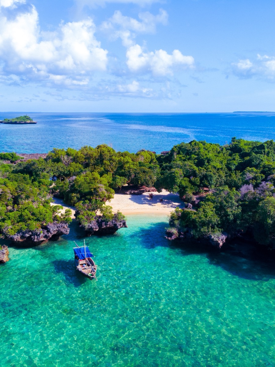 Zanzibar kıyısında turkuaz lagün ve geleneksel yelkenli